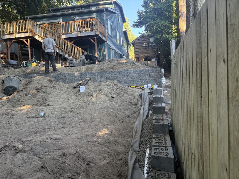 Block retaining wall being built with drainage behind it