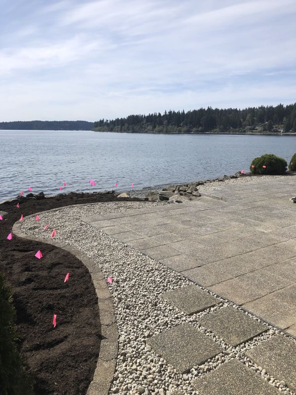 Large stone slab patio with a gravel border on a waterfront lot